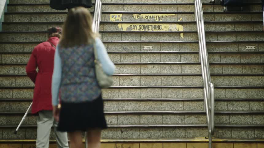 Various people go up and down a flight of stairs