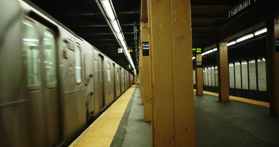 A subway train moves through an underground station