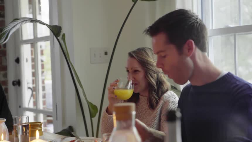People at home sitting at a table and drinking juice and eating