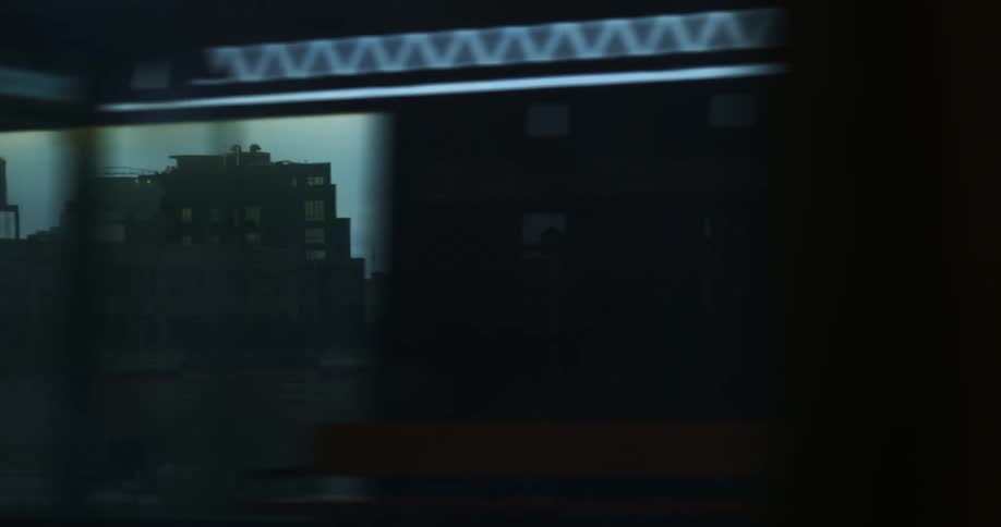 A train passes by a station and then a part of a downtown area of a city