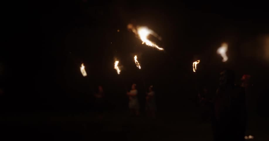People walking with burning torches at night
