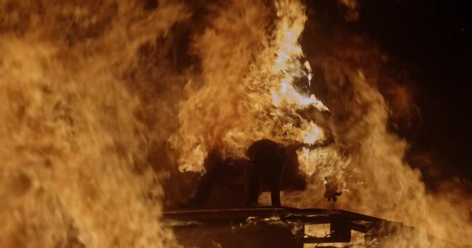 A humanlike figure burns in a roaring bonfire