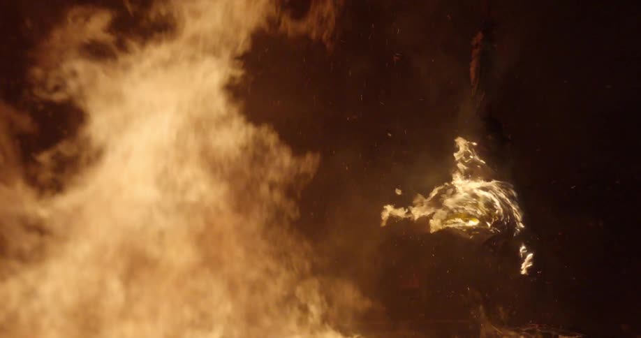A statue of a man on a horse burns at night