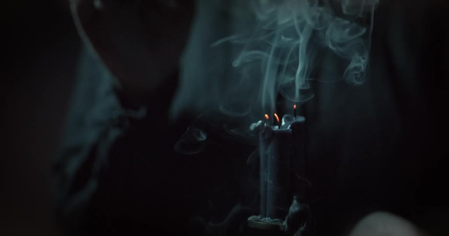 A person puts out the flame on a candle