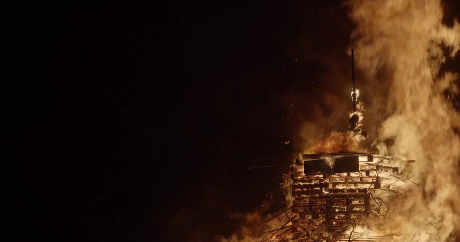 A large bonfire consumes a big pile of pallets and other wooden objects
