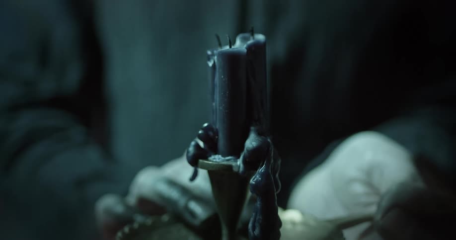 A person holds an almost melted candle in their hands