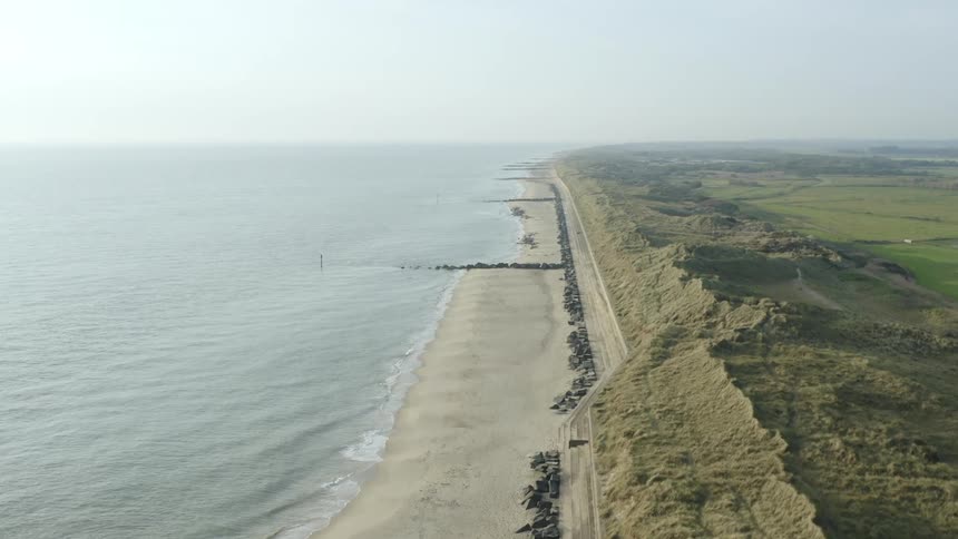Aerial view of calm sea waves crashing on the shore of a beach