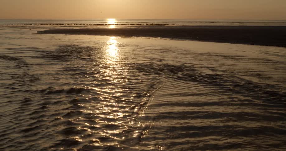 The sun rises over an inlet in the ocean