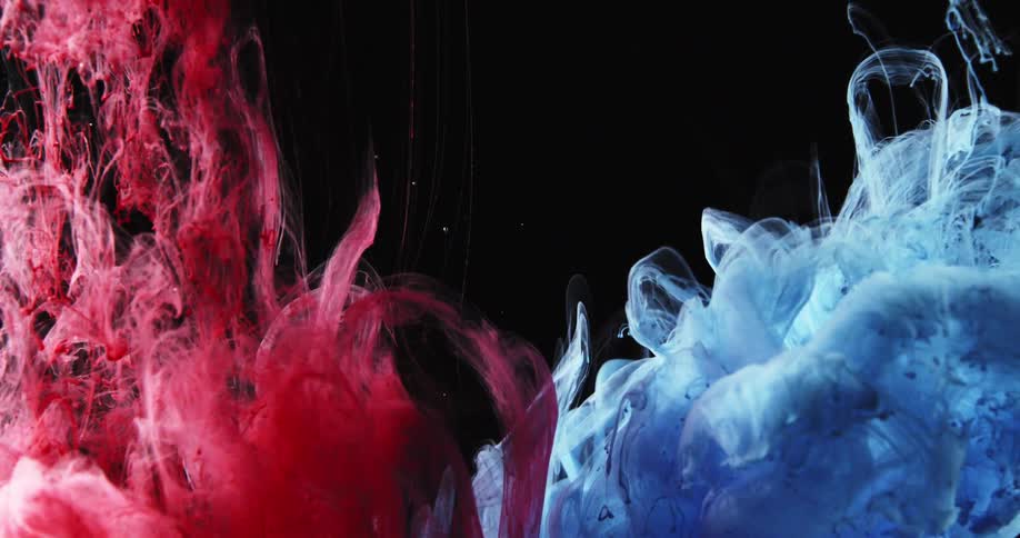 Blue and red clumps of tendrils flow in dark sending up bubbles