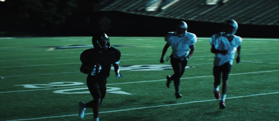 A football jumps over another player and runs to the end zone