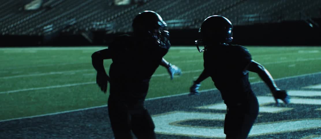 Two football players shake hands and body slam one another