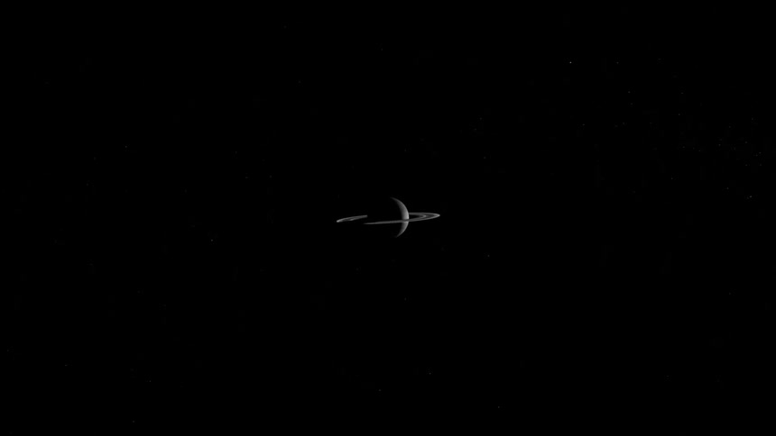 The planet saturn with rings visible hangs in outer space