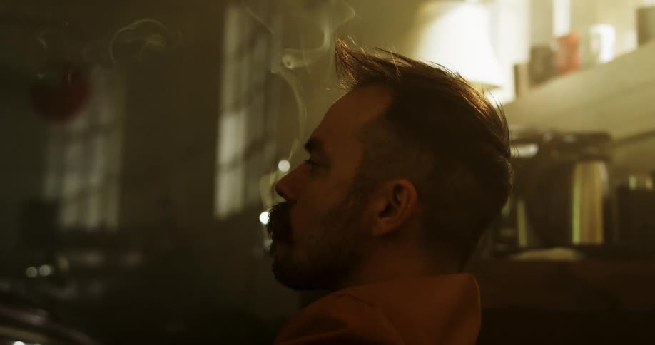 A man is smoking a cigar in his home
