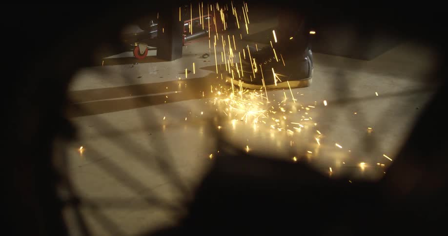 Sparks hit the floor as a person works in the shop