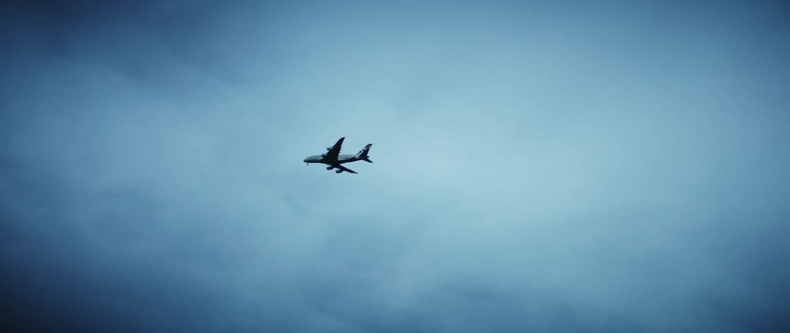 Airplane flying above across bright blue skies