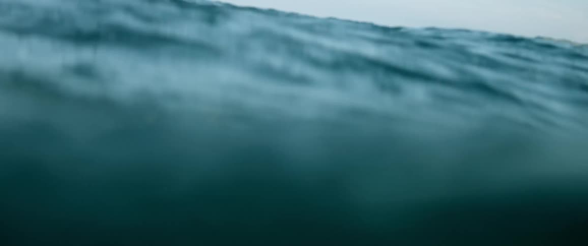 Turquoise blue waves crash in the ocean on a clear day