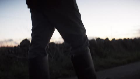 A man hikes on a trail at sunset