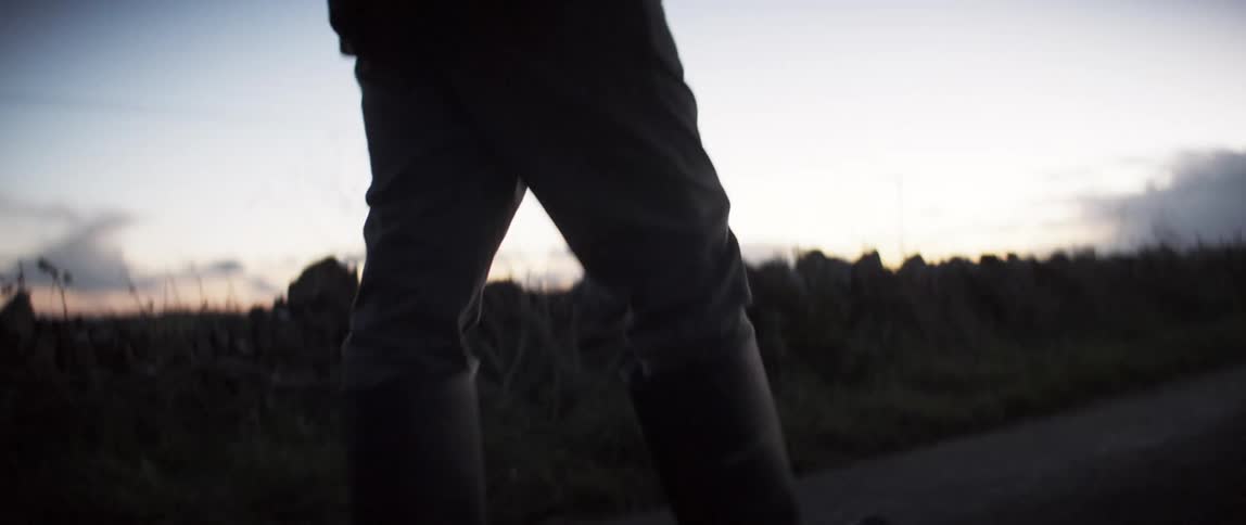 A man hikes on a trail at sunset