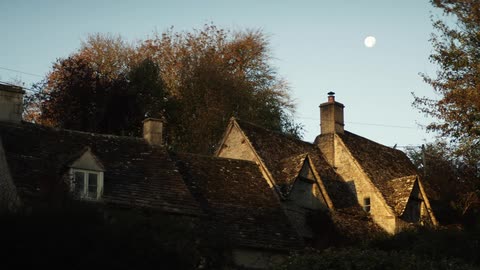 The sun is rising behind the homes