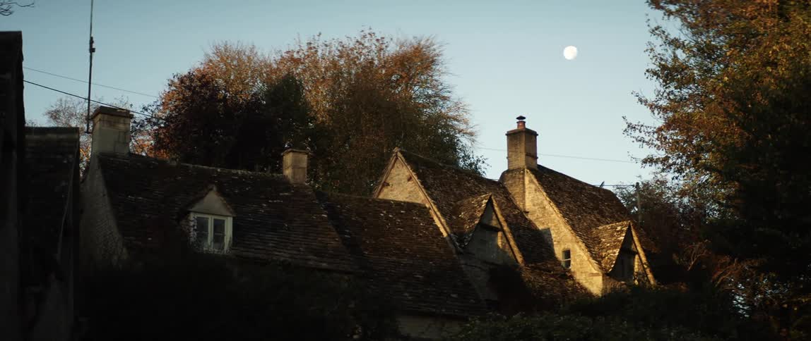 The sun is rising behind the homes