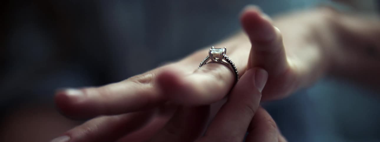 A woman struggles to remove her engagement ring from her finger