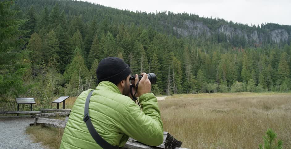 A man takes pictures of a forest