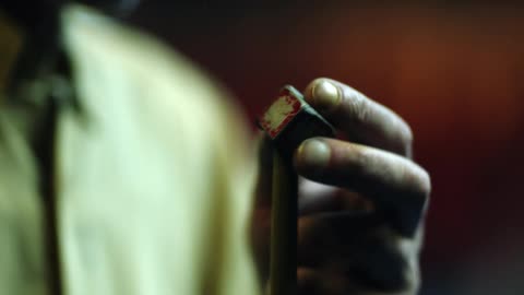 A man puts chalk on a pool stick