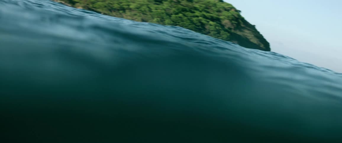 Waves in the water with trees in the background