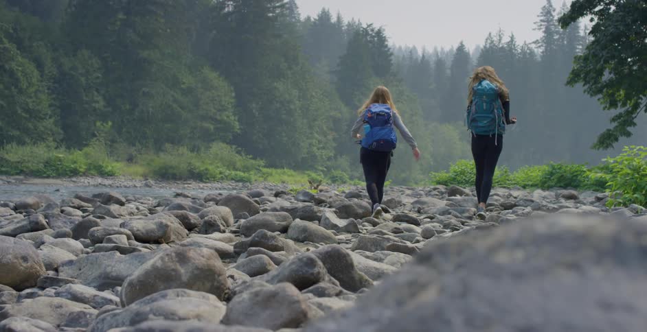 Two teenagers hiking next to a river