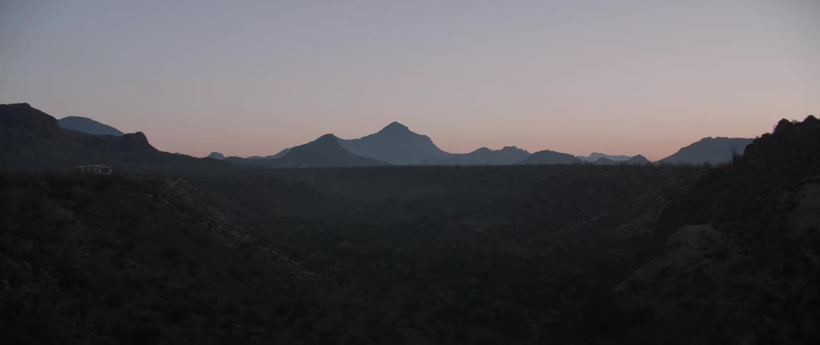 Rocky peaks and brush in a desert at sunrise
