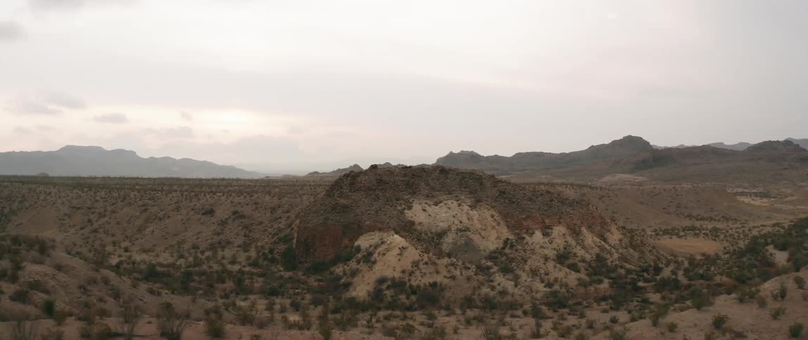 The hills are brown with fog covering the mountains in the distance