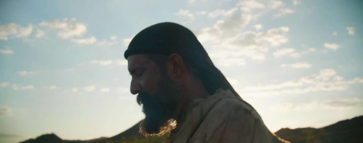 A man walks outside as the sun starts to set
