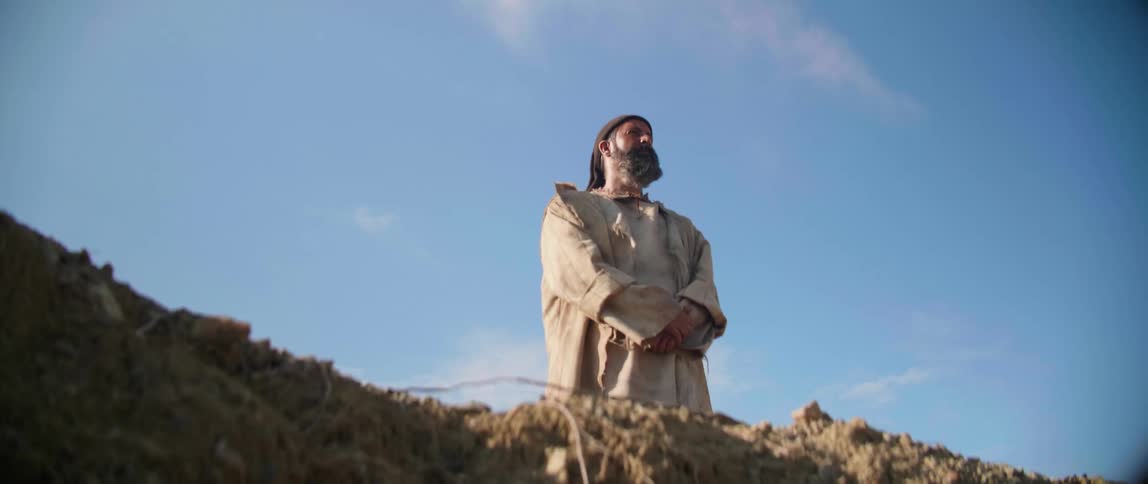 Man stands on top of hill looking outward