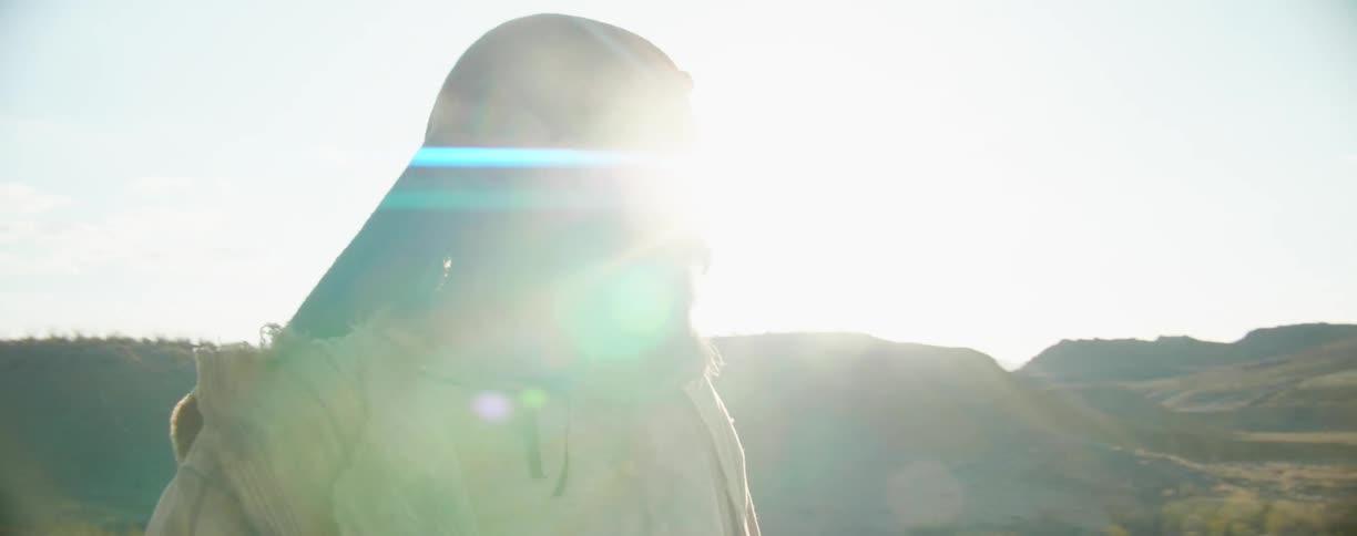 A man standing in the hills looks around