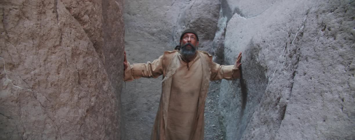 A man leans against the rocks of the canyon
