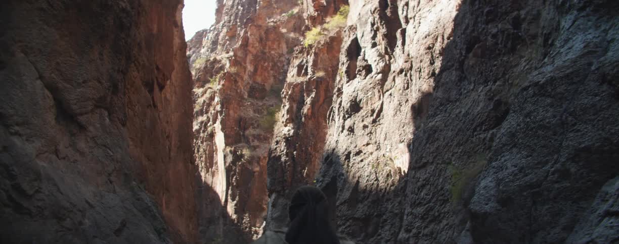 A man walking between cliffs