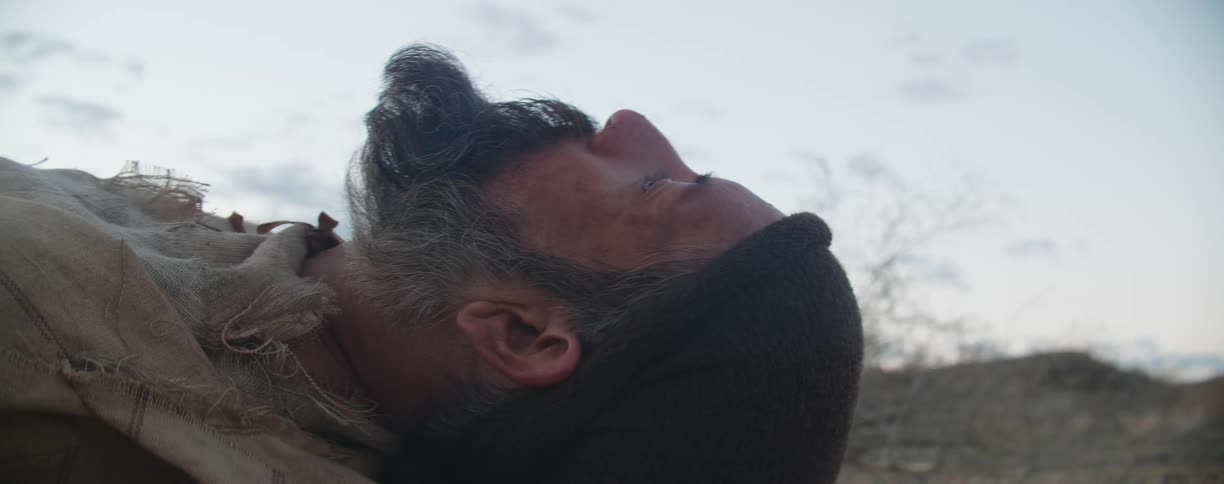 A man wakes up sleeping on the ground