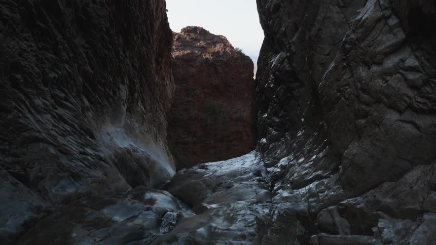 Water flows under and over rock in a gorge