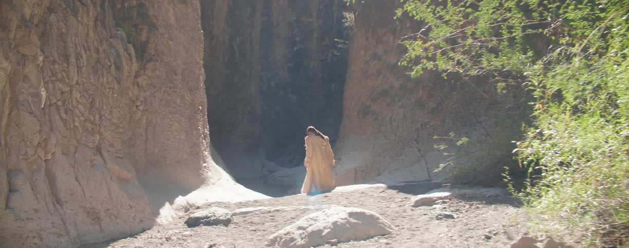 A man is hiking down past the canyon
