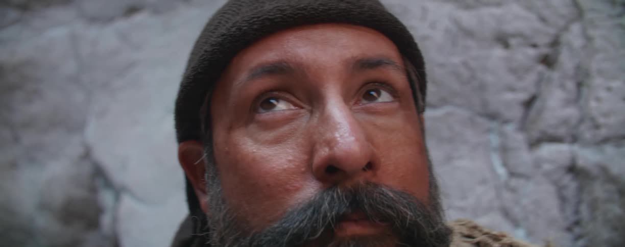 A man is looking around by the rocks