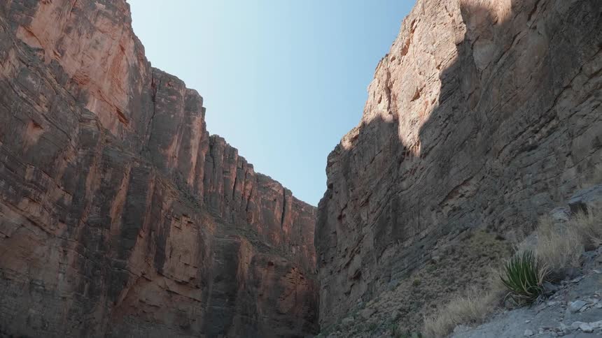 The sheer walls of a tall canyon on a sunny day