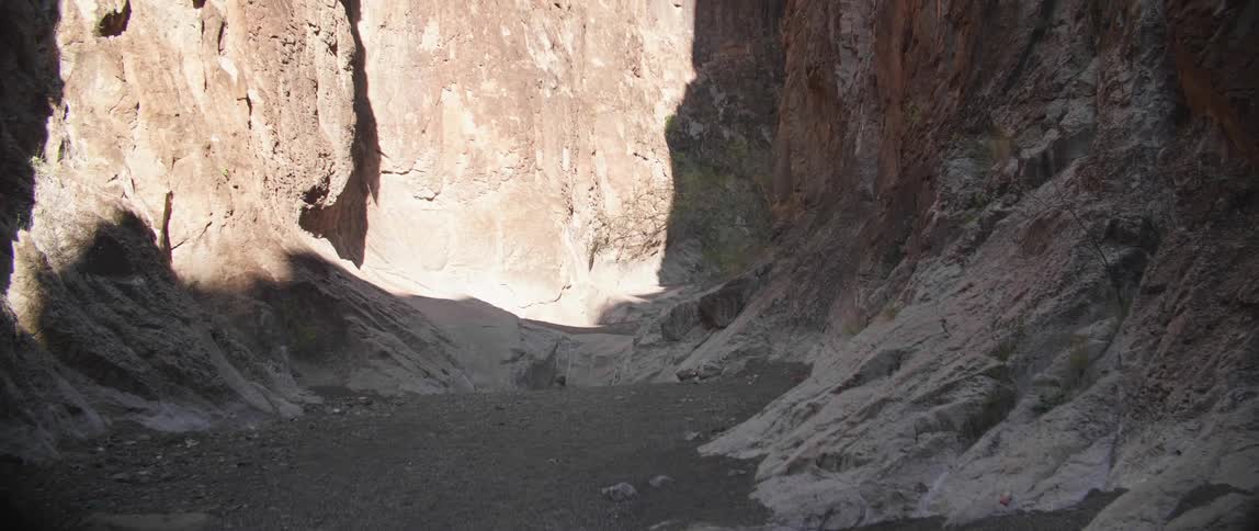 The canyon is dry and covered in shadow