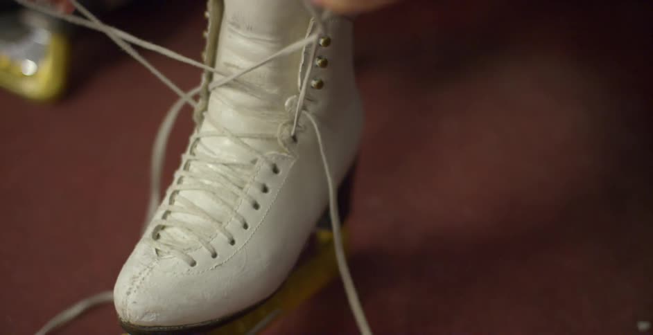 A woman puts on an ice skate