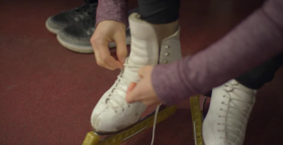 A woman puts on ice skates