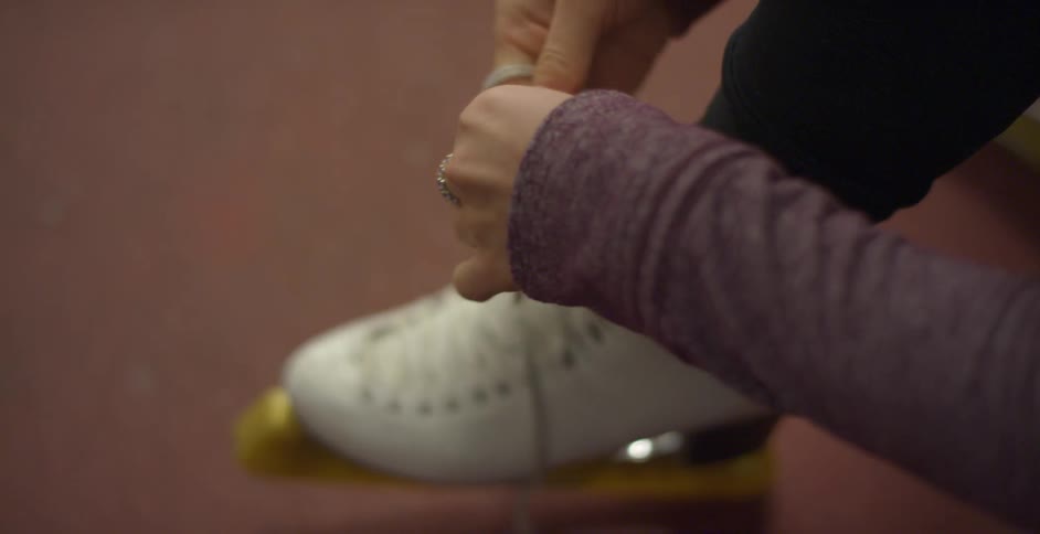 A woman tying her figure skate