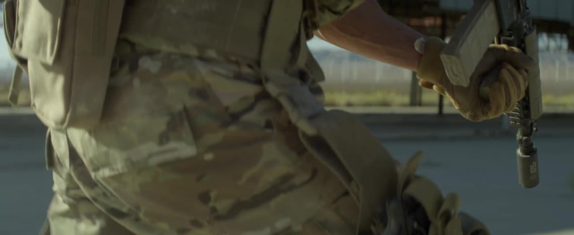 A soldier with a rifle runs through smoke outdoors