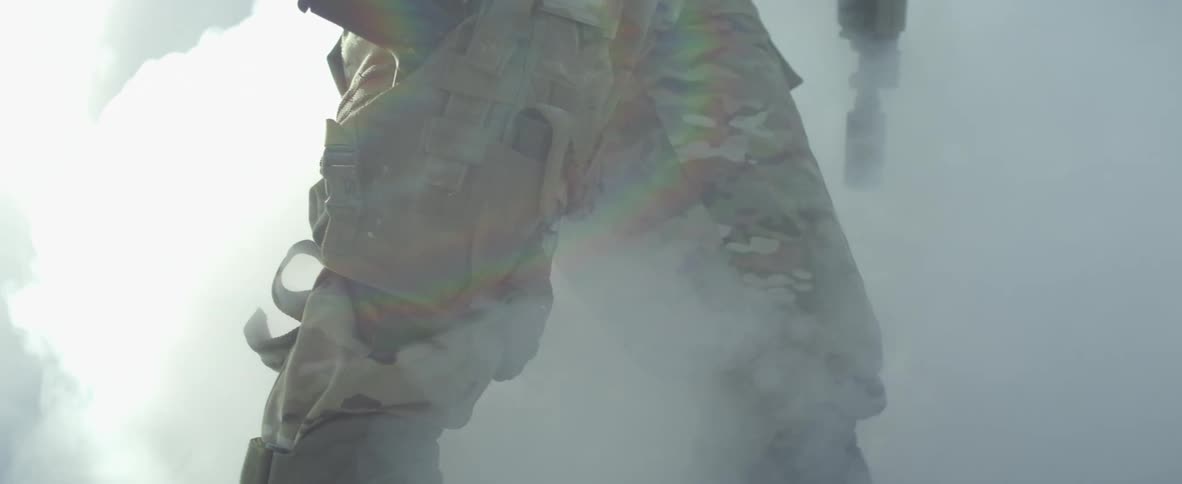 Smoke surrounds a soldier with weapons