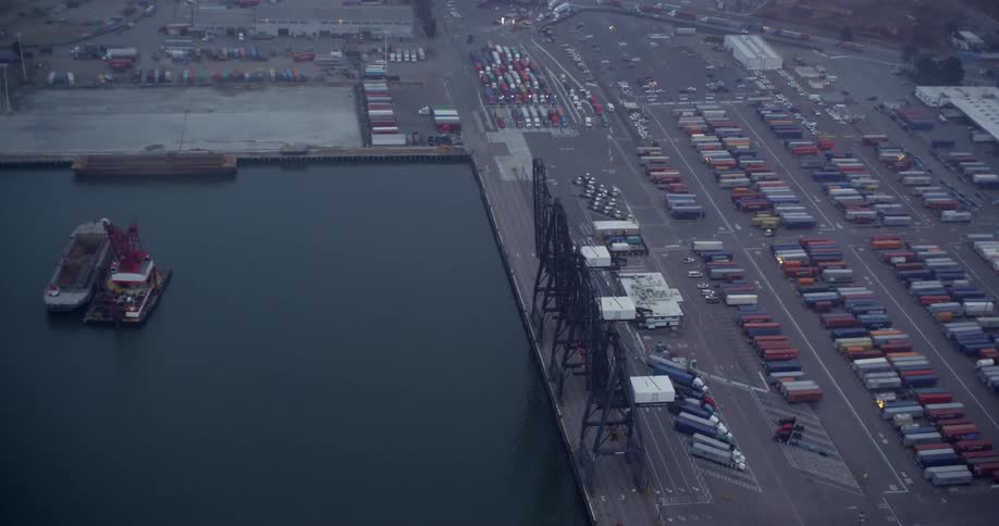 Freighters occupy water near lots of shipping containers