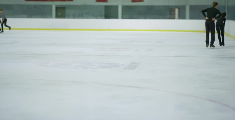 Young people ice skating in an indoors ice skating rink