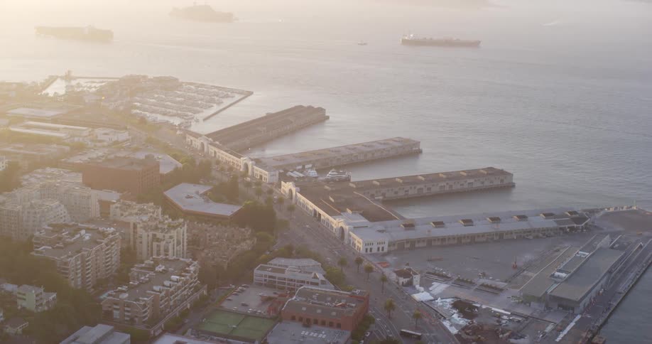 A coastal port with buildings roads ships and the ocean in the background